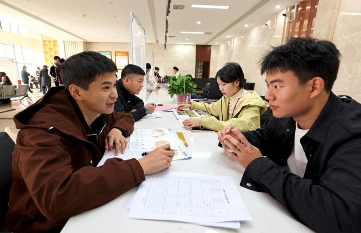 招聘会现场,应聘者与企业负责人交流。梅建广 摄