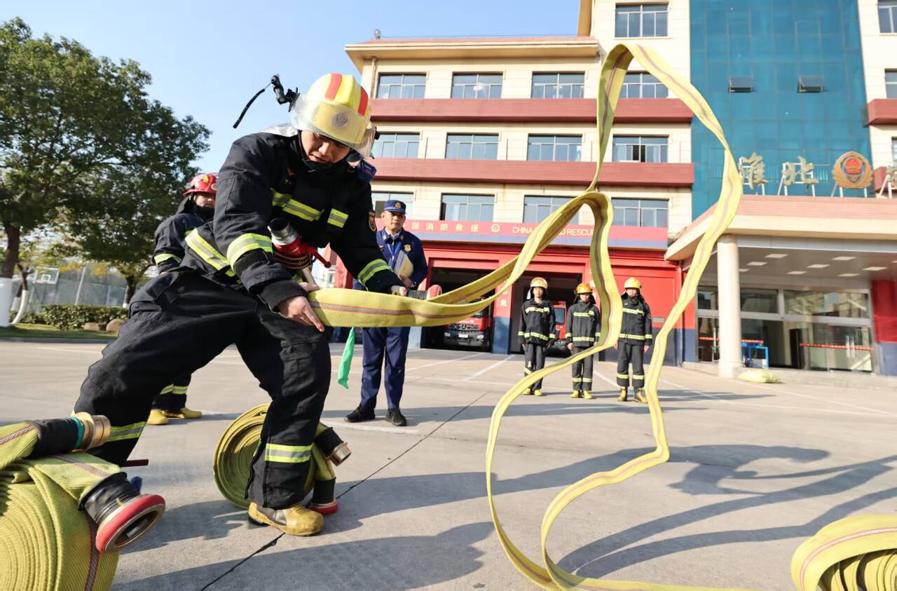 选手在对抗竞赛上进行一人三盘水带连接项目比赛。