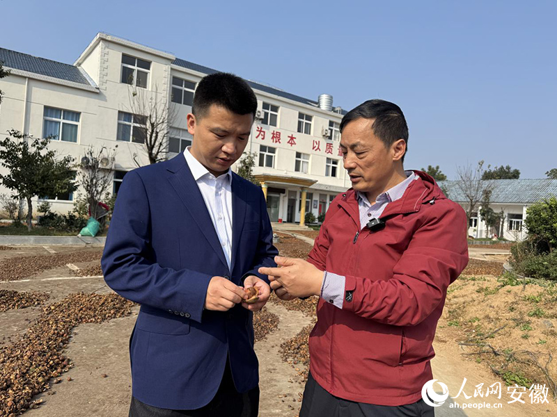 交通银行工作人员（左）与詹文勇交流。人民网记者 胡雨松摄