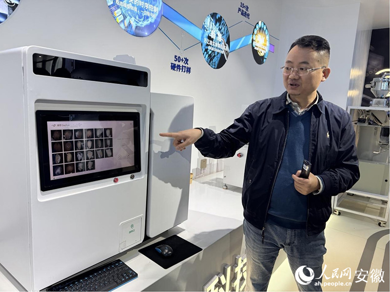 武勇介绍企业设备。人民网记者 胡雨松摄