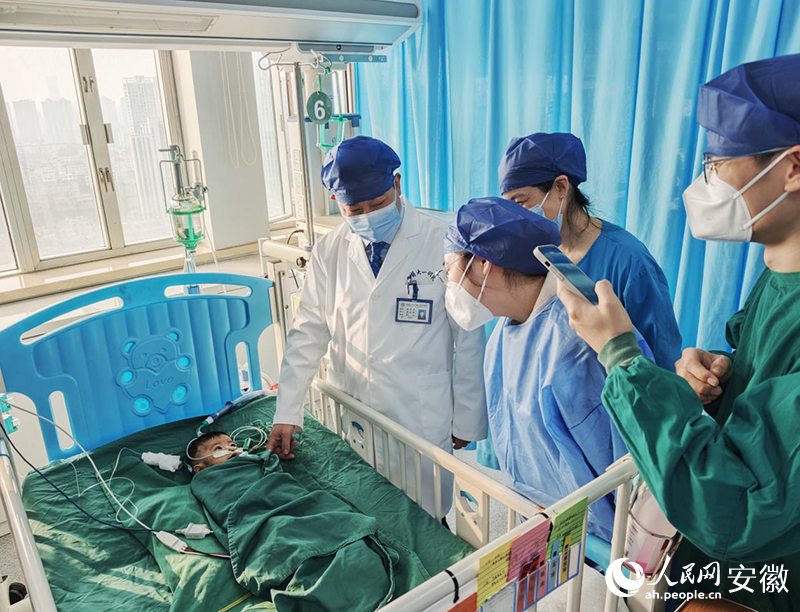 孙倍成与孩子父母一起看望手术成功的小彩虹。人民网记者 周坤摄