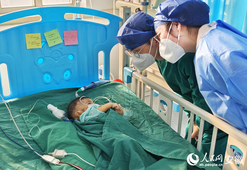 父母在病床头贴上对孩子的祝福条。人民网记者 周坤摄