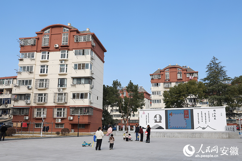 沐浴冬日暖阳，居民在小区广场遛娃。人民网记者 张俊摄