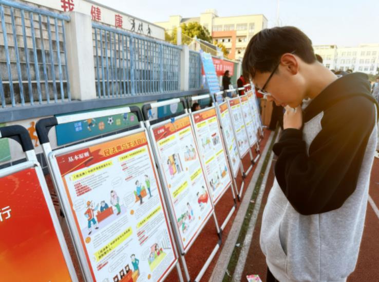 徽州二中学生观看法治展板。