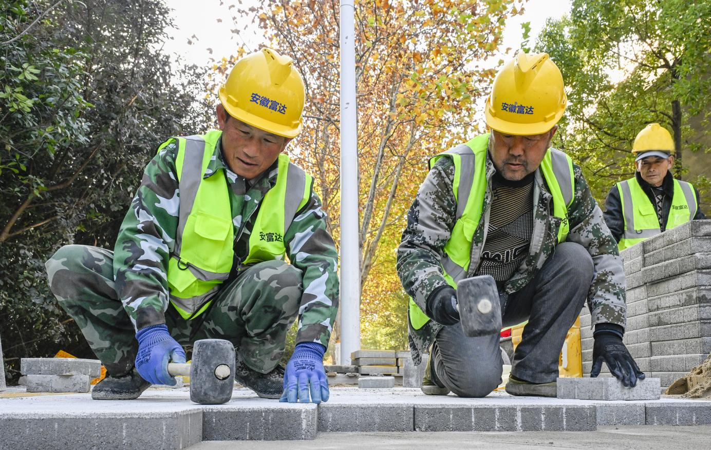 工作人員重新鋪設人行道板磚。趙明攝