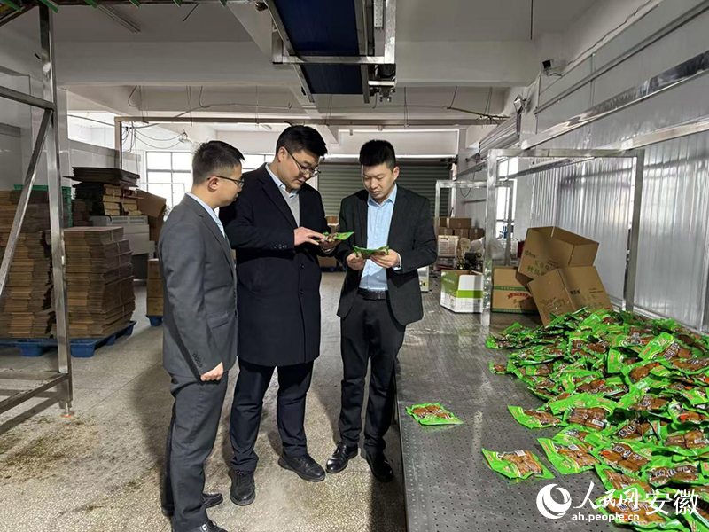 徐浩（右一）向农行客户经理介绍企业豆制品产品。人民网记者 胡雨松摄