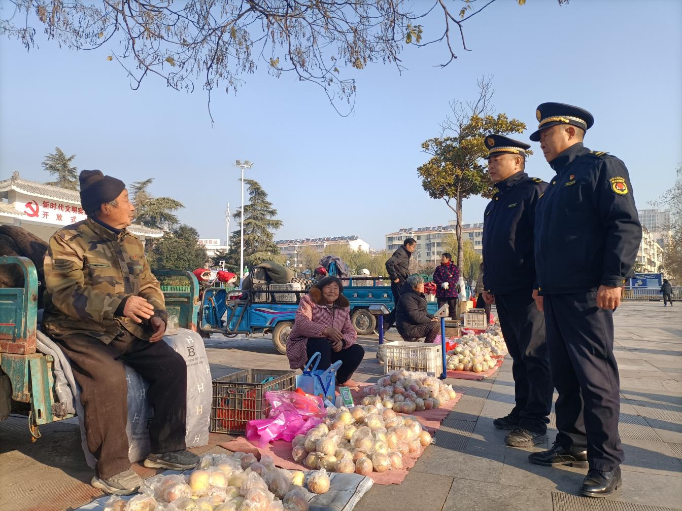 城管執法人員向果農宣傳便民政策。