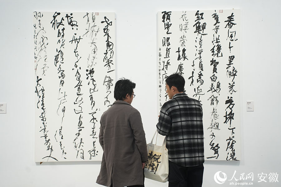 两位参展作者正在交流创作心得。人民网记者 王锐摄