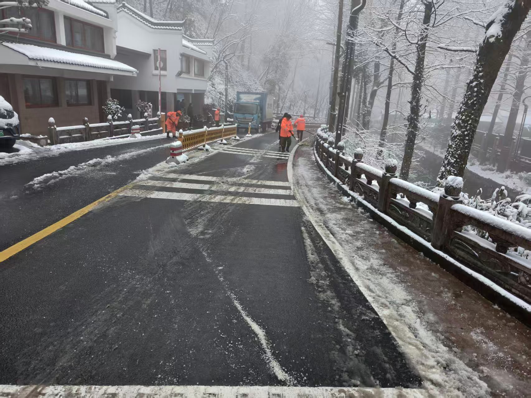 池州市公路部门人员清除S228九华街区至后山段积雪。