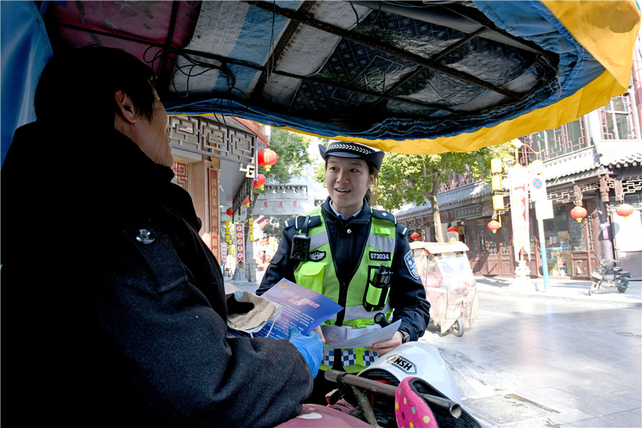 交警金安琪向三輪車主宣傳交通安全知識。