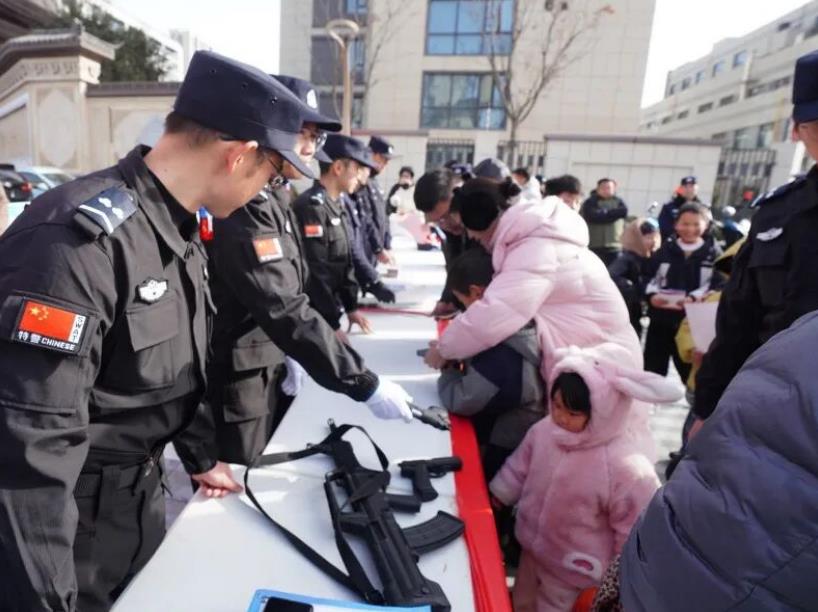 民警在向过往群众展示讲解枪械、仿真毒品模型等。韩雪凯摄