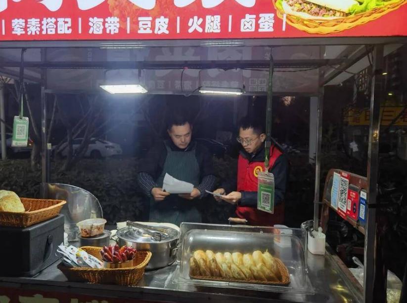 花亭湖街區黨支部現場登記攤主信息和經營內容。