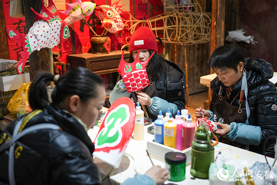 游客在张婷的鱼灯工坊体验鱼灯制作。人民网记者 王锐摄