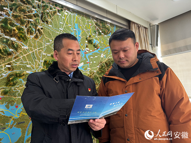 安庆港航中心工作人员在给夏先成（右）介绍“信用+”场景。人民网记者 胡雨松摄