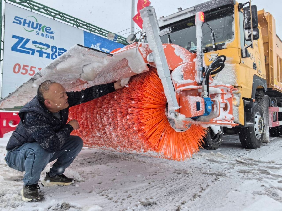 合芜中心除雪车操作手杨雄志清除除雪车辆积雪。