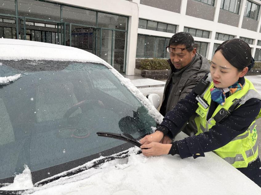 黄山北门站蒋洋洋风雪中帮助司机检修雨刮器。安徽交控集团黄山管理中心供图