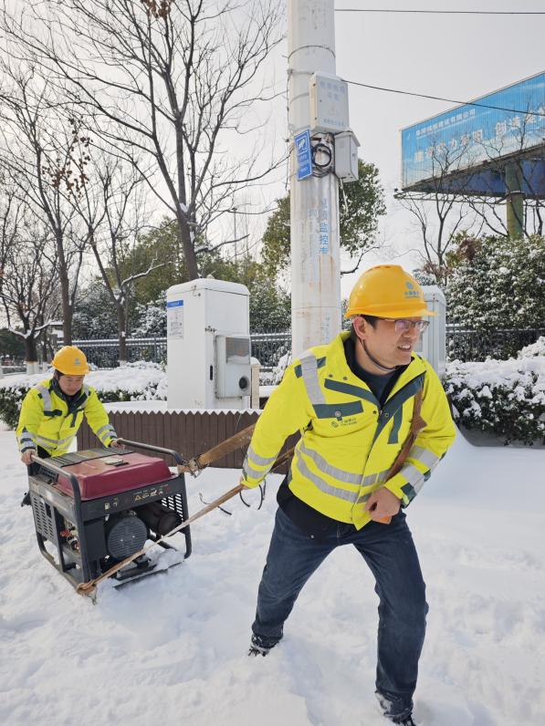 裝維人員手拉發動機在雪地裡行走。安徽移動供圖