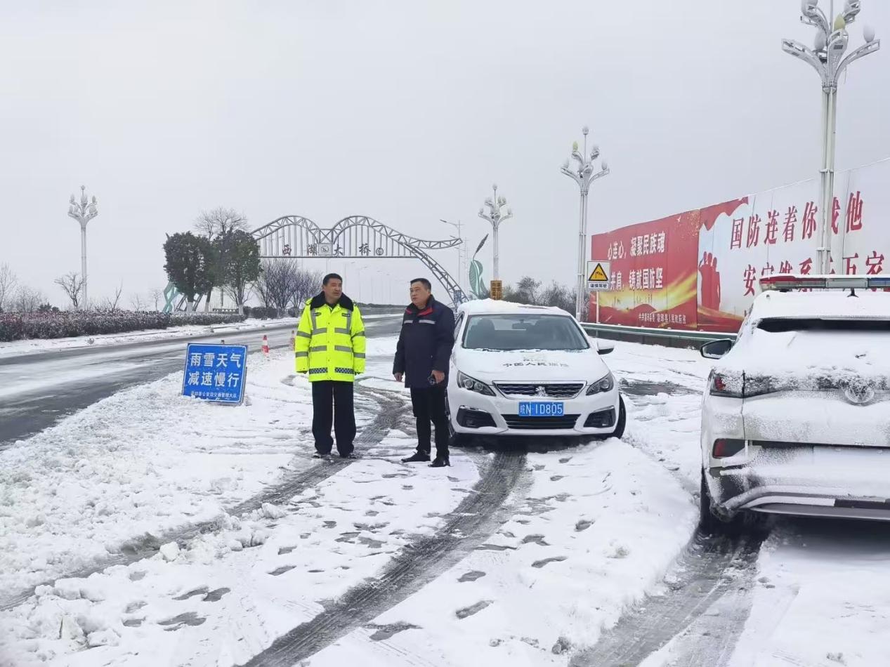 六安霍邱理赔分部党员张立平与交警在易结冰路段值守。
