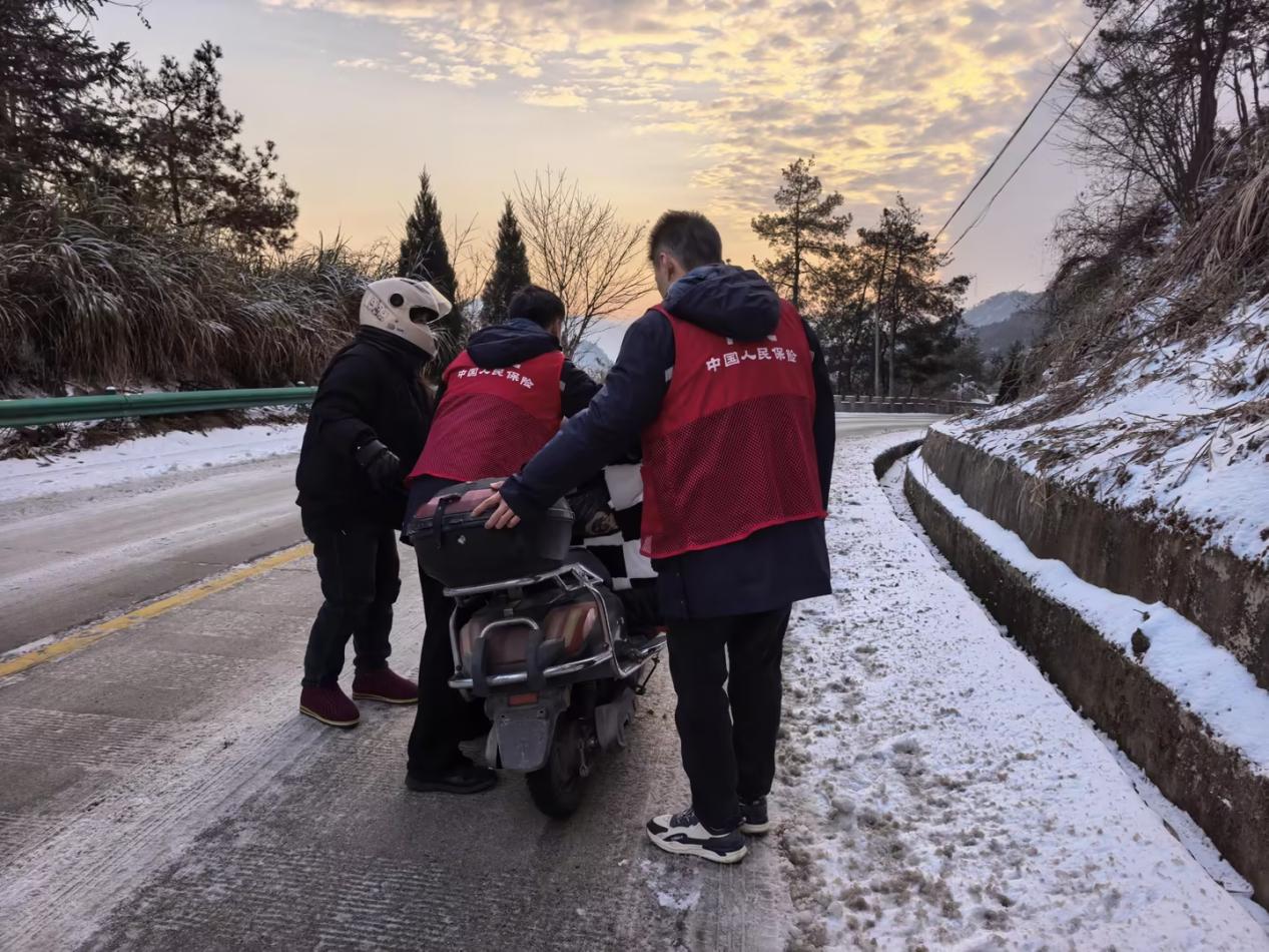 安庆理赔员王海洋、杨少文帮助车主推车。