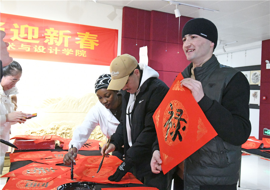留学生在书法老师指导下体验写“福”字和春联。