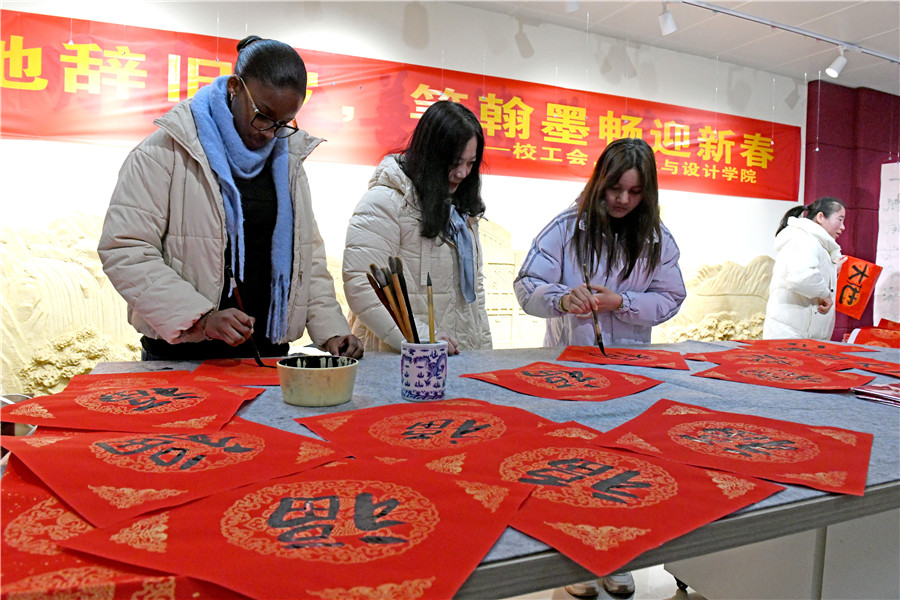 留学生在书法老师指导下体验写“福”字和春联。