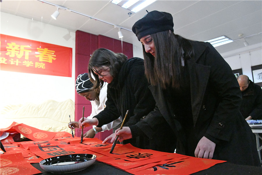留学生在书法老师指导下体验写“福”字和春联。