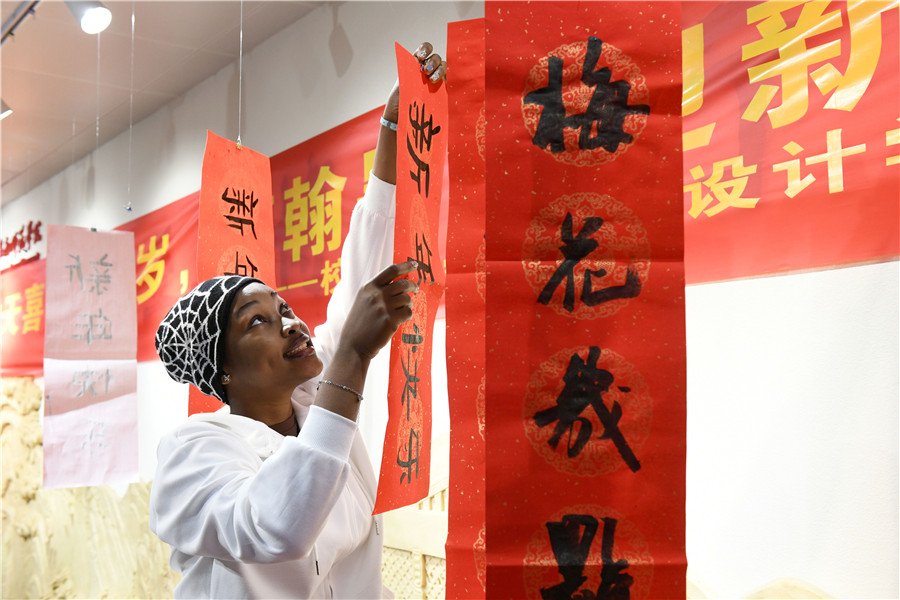 留学生在书法老师指导下体验写“福”字和春联。