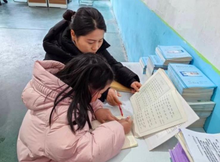 老师课后耐心辅导学生写作业。