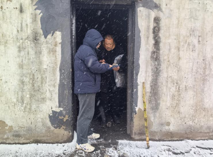 彭塔镇民政办主任曹杰为困难群众送羽绒服。彭塔镇供图