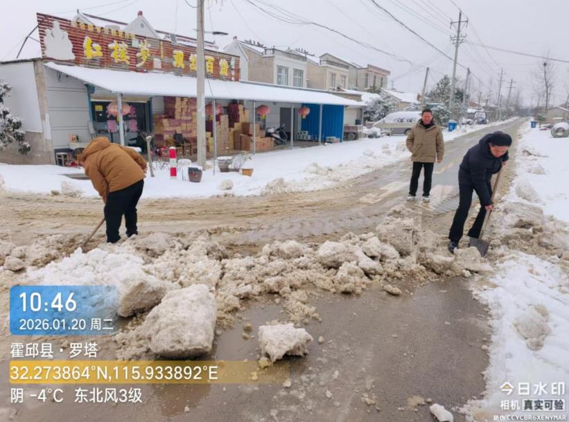 马店镇李西圩村驻村副点长李同威与驻村点长余海在清理路上积雪。马店镇供图
