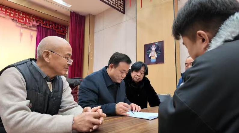 李俊民(左二)与群众商讨提案内容。