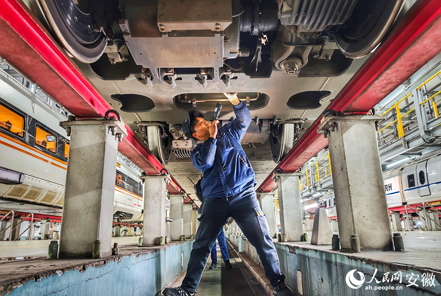 检修人员钻进车底检修复兴号。人民网记者 周坤摄
