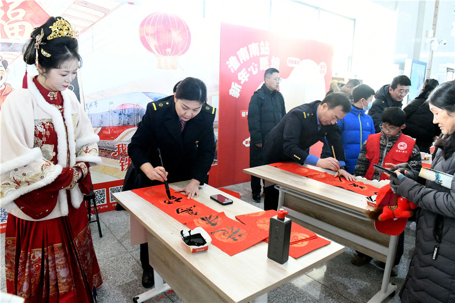 安徽淮南南站，铁路职工为候车旅客书写春联。