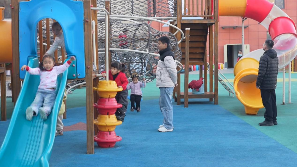 幼儿园的小朋友在老师的看护下,玩耍滑梯等园内设施。赵宇摄