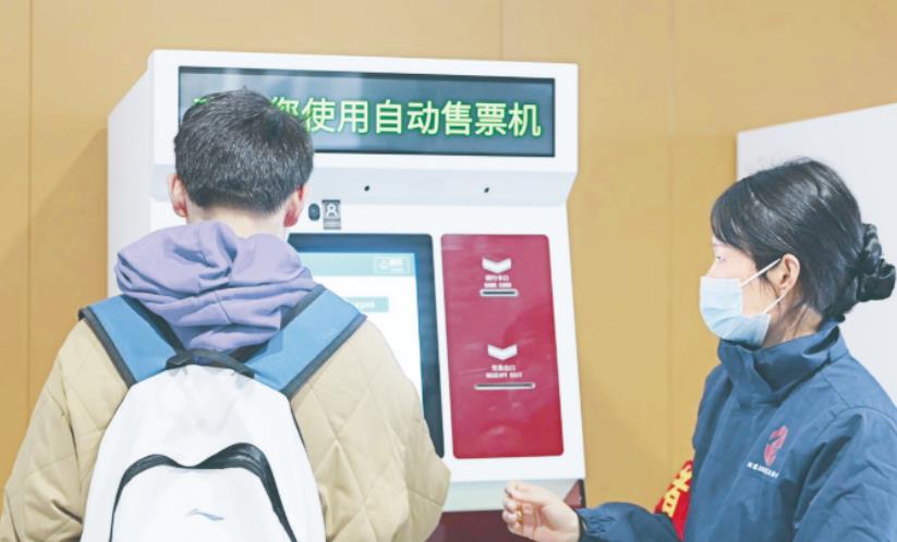 志愿者帮助旅客在售票机购票。周虹光摄