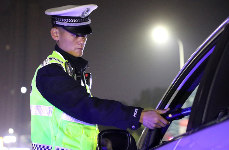 执勤交警在对驾驶员进行酒精测试。