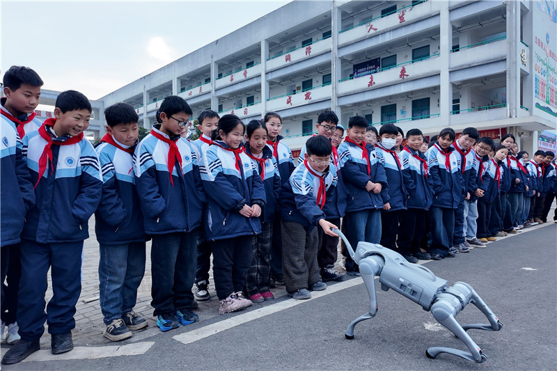 胡集镇中心学校“科技‘马’上乐”活动,学生与机器狗互动。利辛县文旅局供图