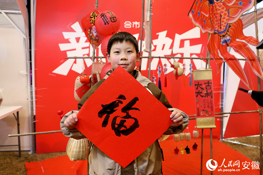小朋友正在展示机器人给他写的“福”字。人民网 郭昊摄