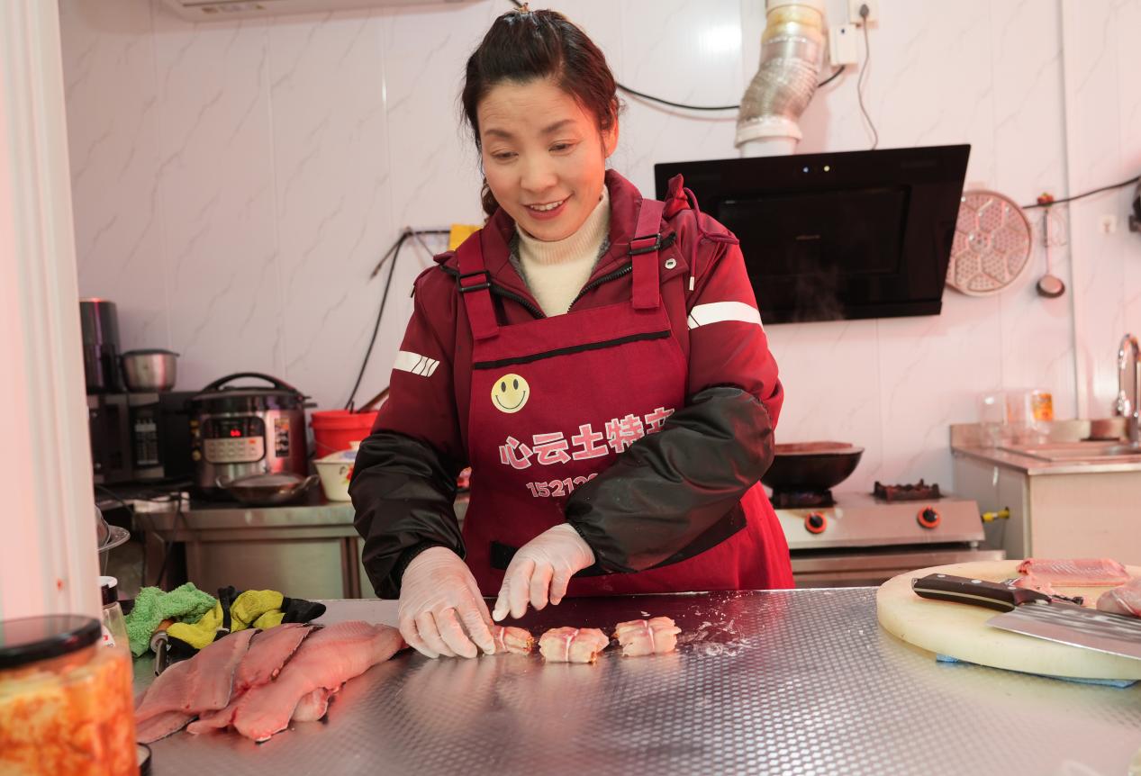 谢金荣正在制作特色美食攘乌鱼。