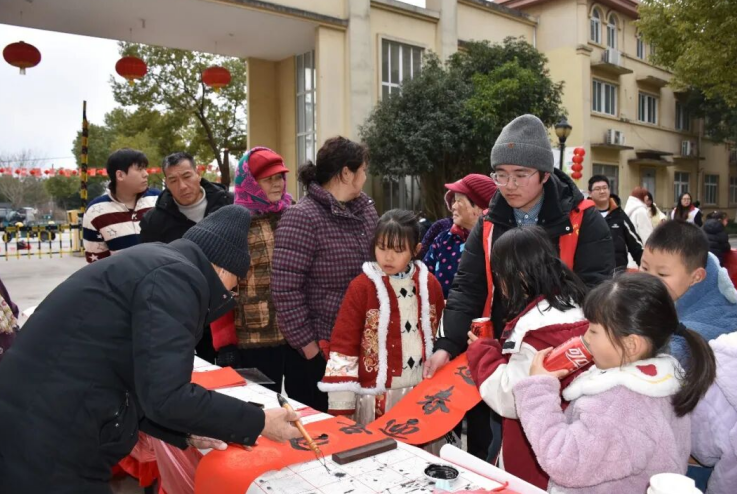 书法老师写春联赠给居民。