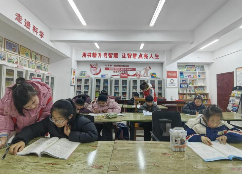 大学生志愿者指导小朋友阅读。许凯摄