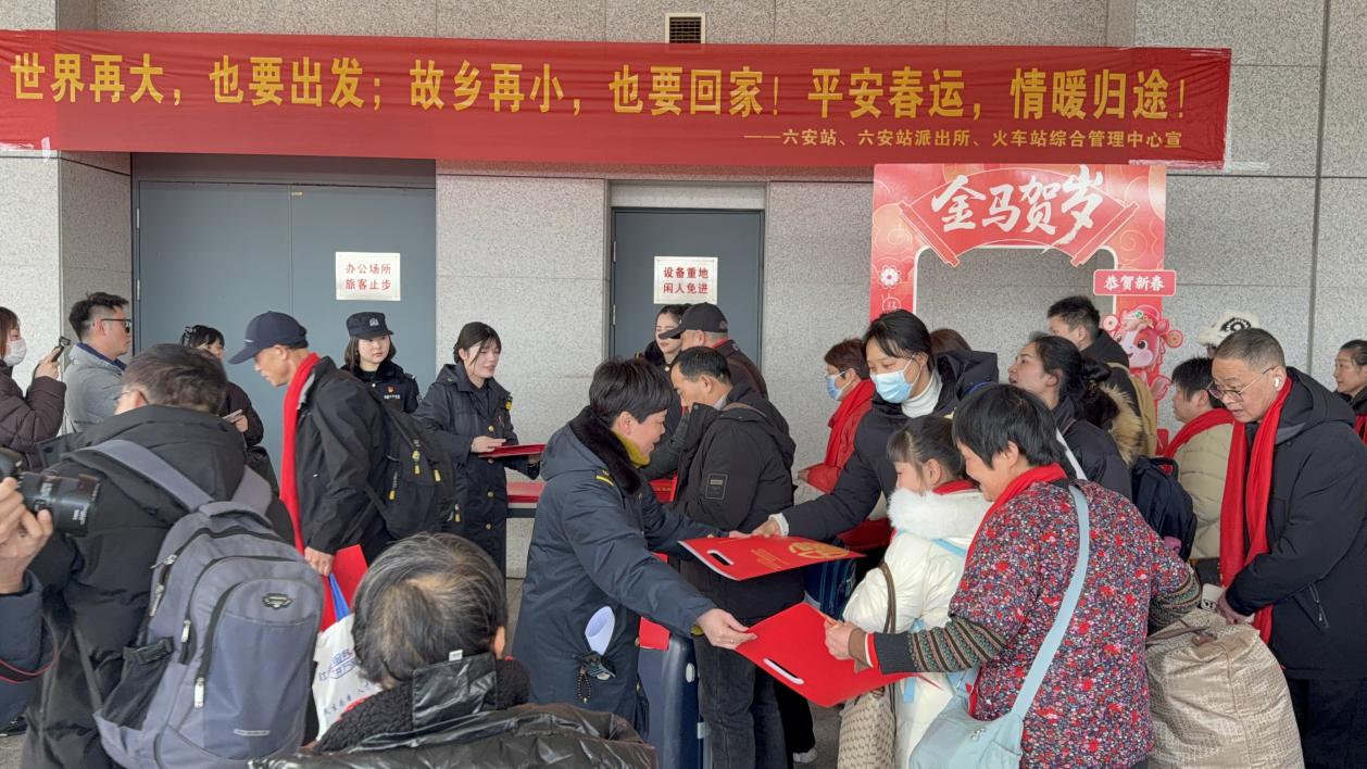 六安火车站民警与车站职工向返乡旅客发送春节福袋。成鑫摄