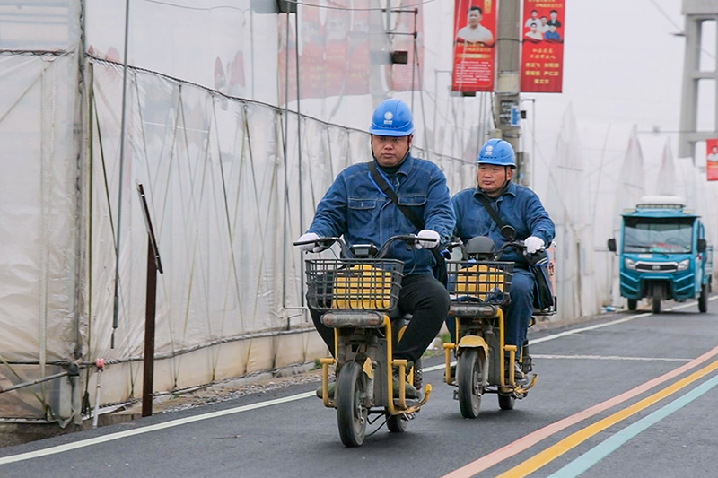 “电力小黄车”穿梭在乡间道路上。王平平摄