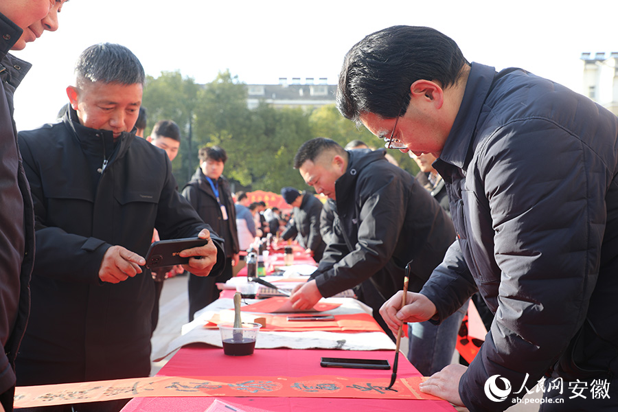 活动现场，书法家正在为群众写春联。人民网 郭昊摄