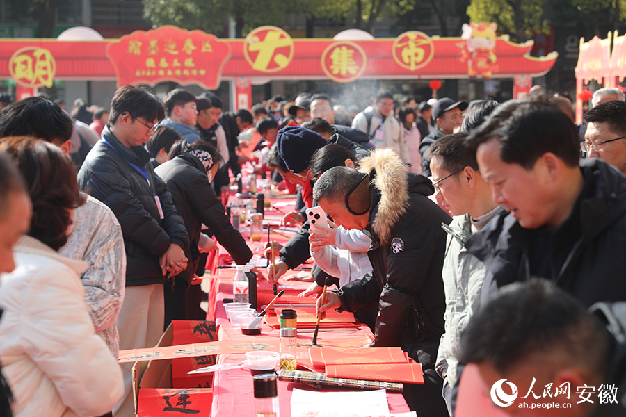 活动现场，书法家正在为群众写春联。人民网 郭昊摄