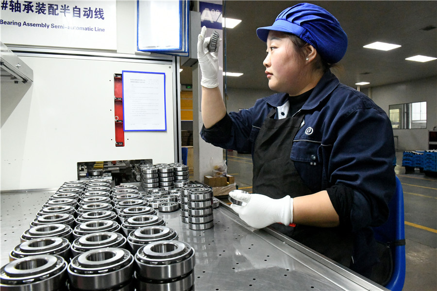 钱潮承（淮南）有限公司工人加工汽车轴承。