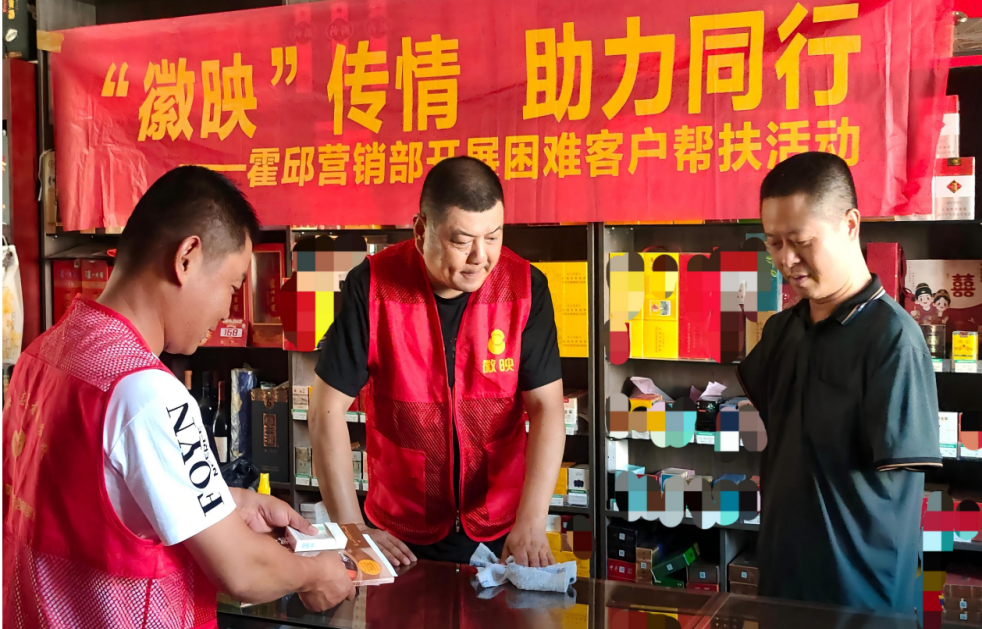 2025年8月，霍邱烟草专卖局志愿者帮助闻义红整理店铺。