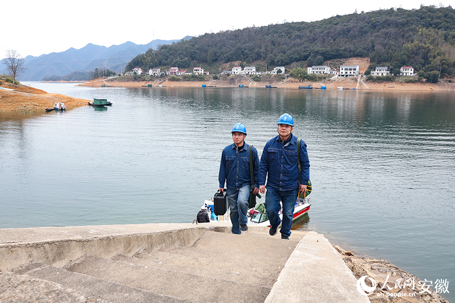 国网黄山市黄山区供电公司员工乘船抵达太平湖腹地的麻川村，巡查线路。人民网记者 张俊摄