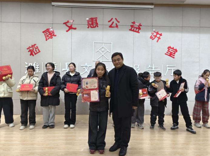 濉溪县文化馆馆长李俊民与竹笛班获奖学员合影。