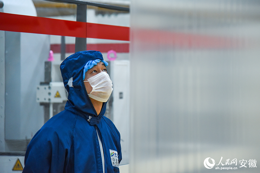 安徽紫江新材料科技有限公司的車間內，工人正在查看產線的運轉情況。人民網記者 李希蒙攝
